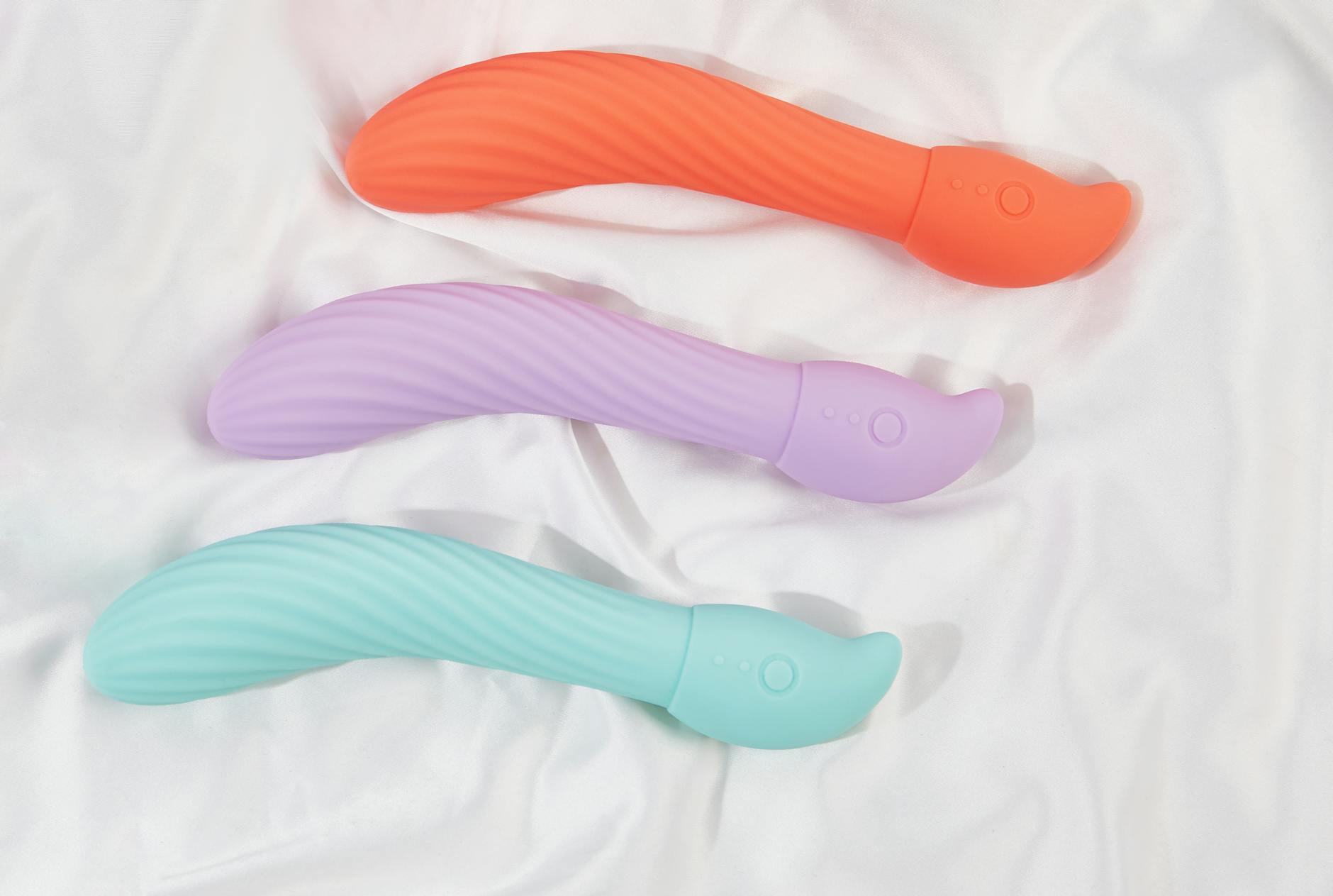 Three colorful lemon vibrators arranged on white fabric, highlighting their smooth texture