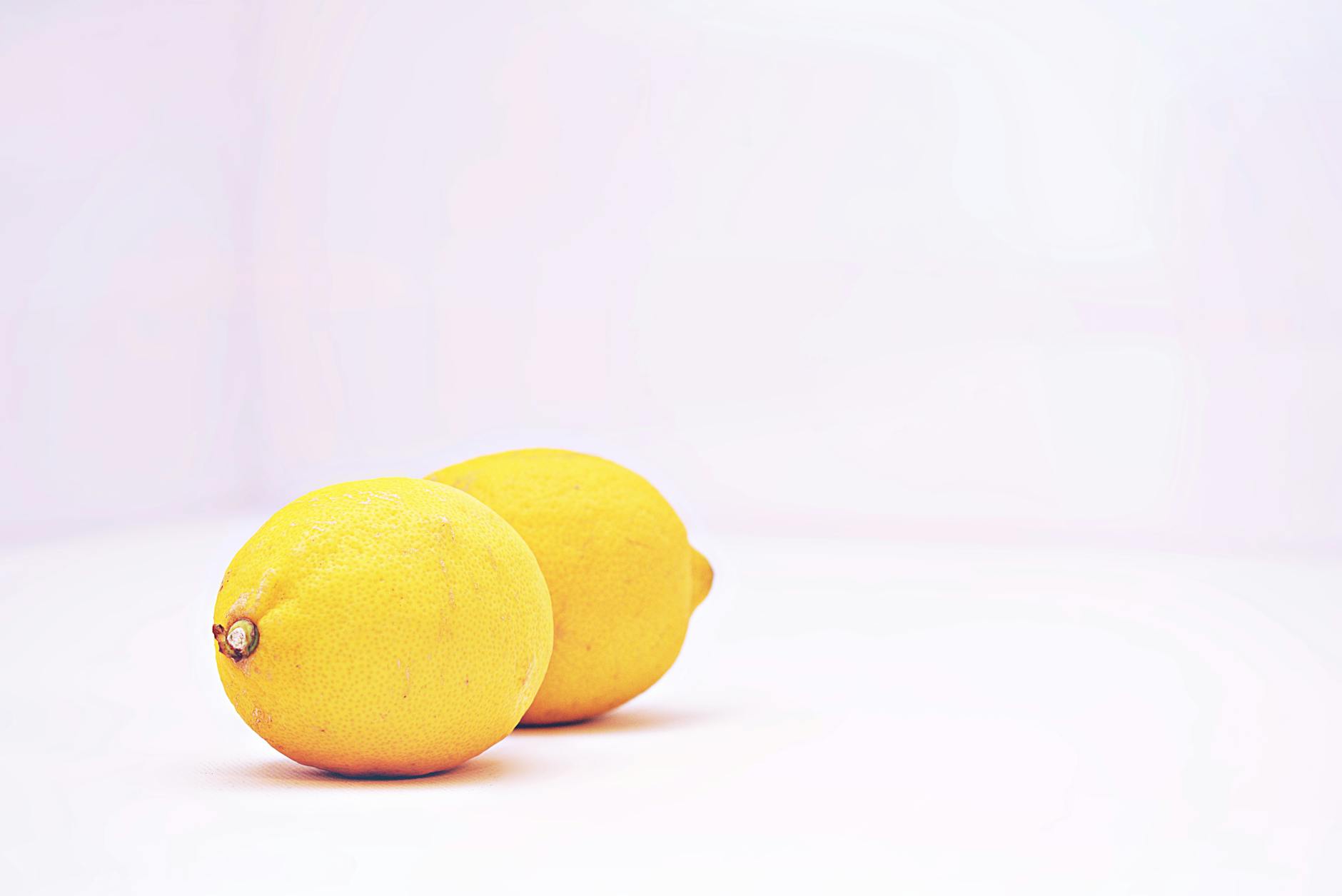 Close-up of two fresh lemons held in cupped hands, symbolizing the softness and sensitivity changes during perimenopause.