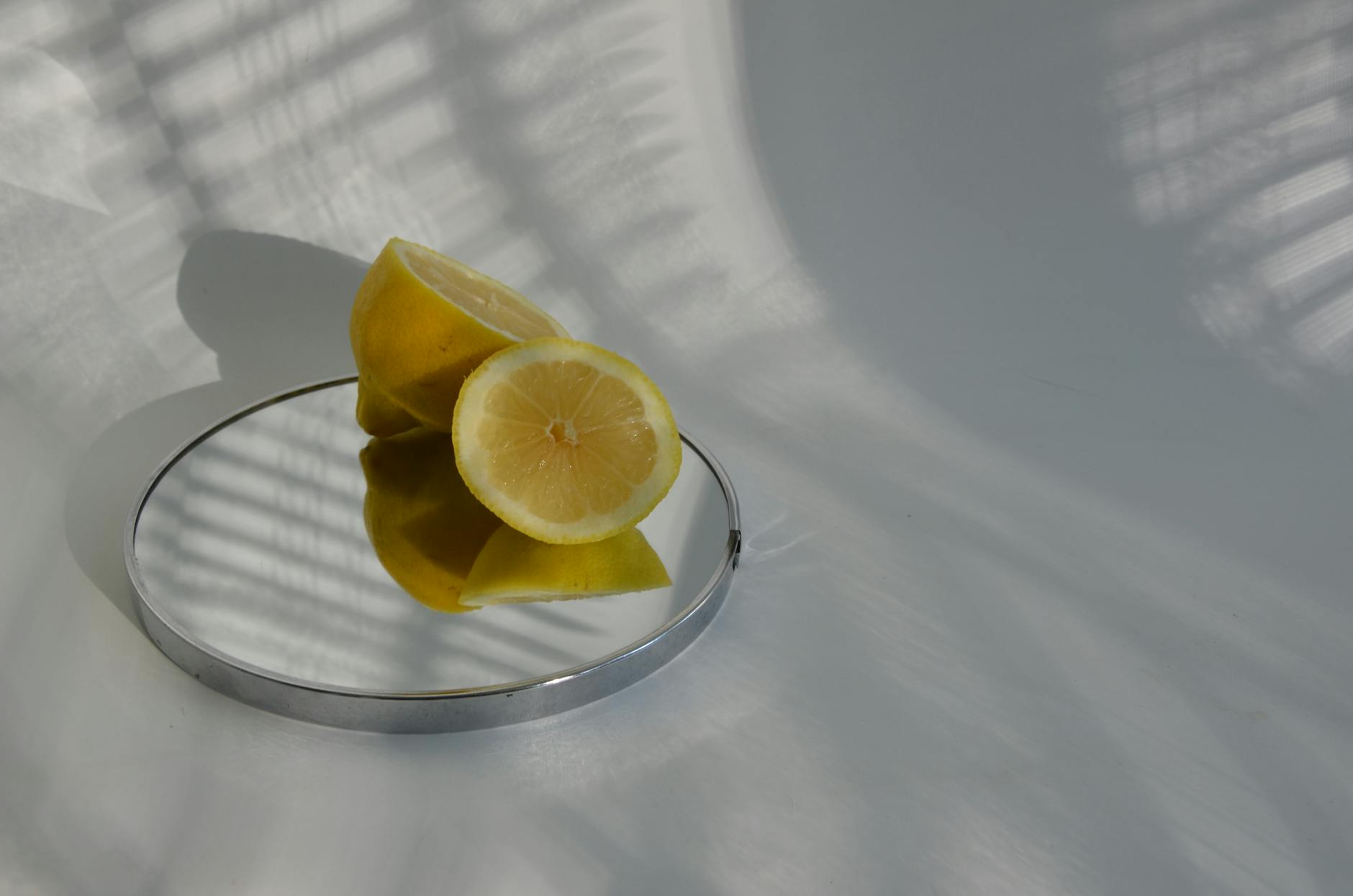 Hand holding a fresh lemon on soft pink background, symbolizing natural body changes and hormonal health